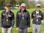 3 golfers wearing medals and smiling at camera